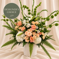 Designer’s Choice Altar Piece: peach and ivory sympathy flowers with Bells of Ireland and layered greenery in a white vessel