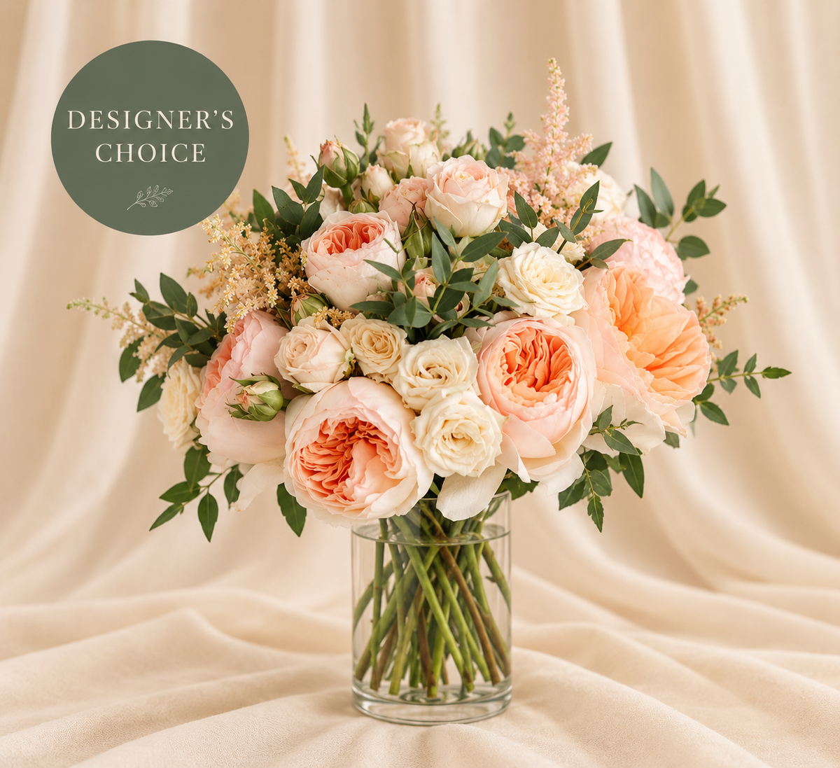 Designer's Choice Pastels bouquet of peach, blush, and cream flowers in a clear vase