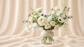 White ranunculus, anemones, pale roses and sweet peas in a cream-and-glass vase.