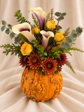 Calla lilies + yellow roses + bronze mums in textured pumpkin vessel